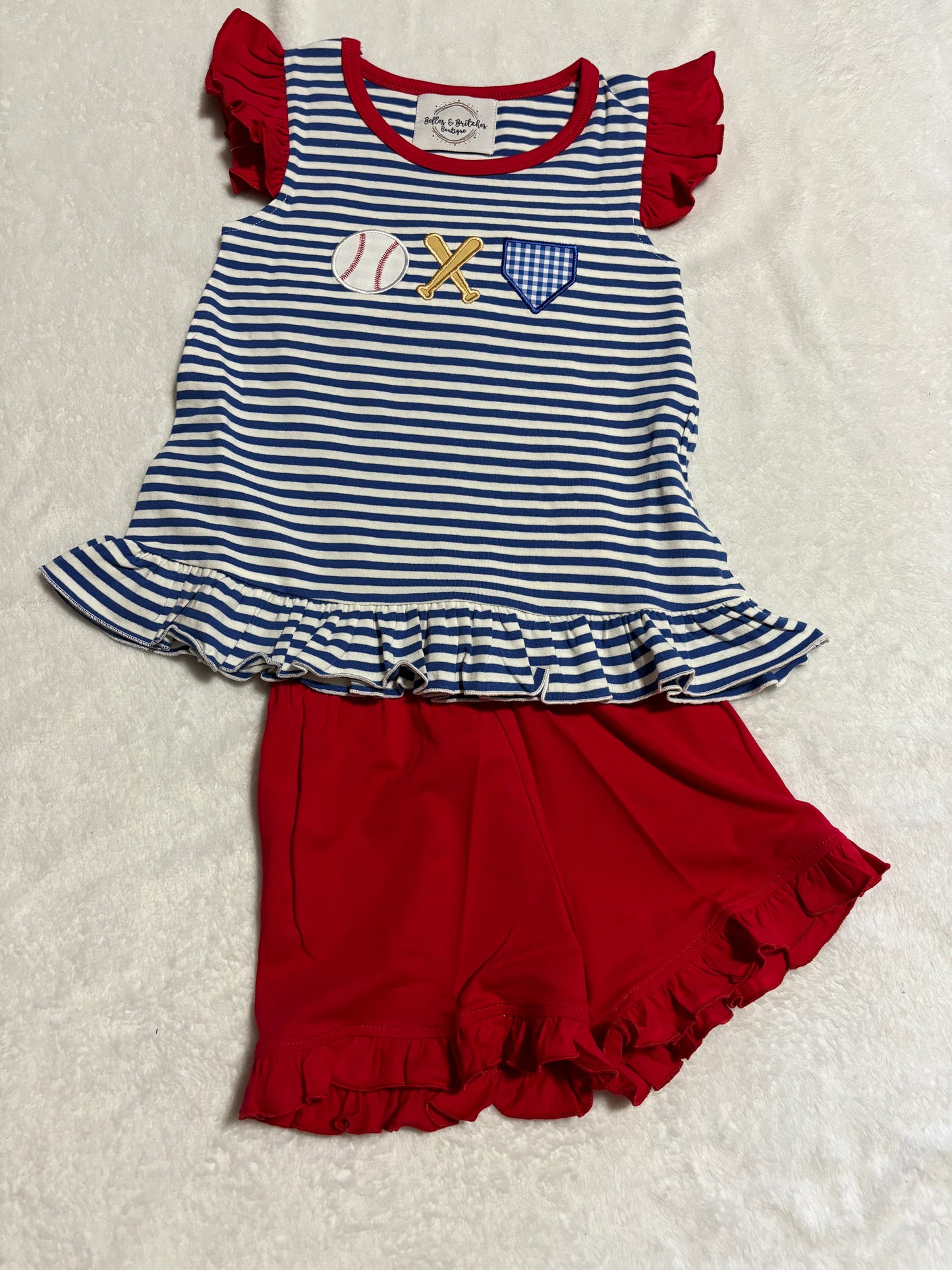 Batter Up girls baseball short set with navy striped ruffle top, baseball appliqué and red ruffle shorts.