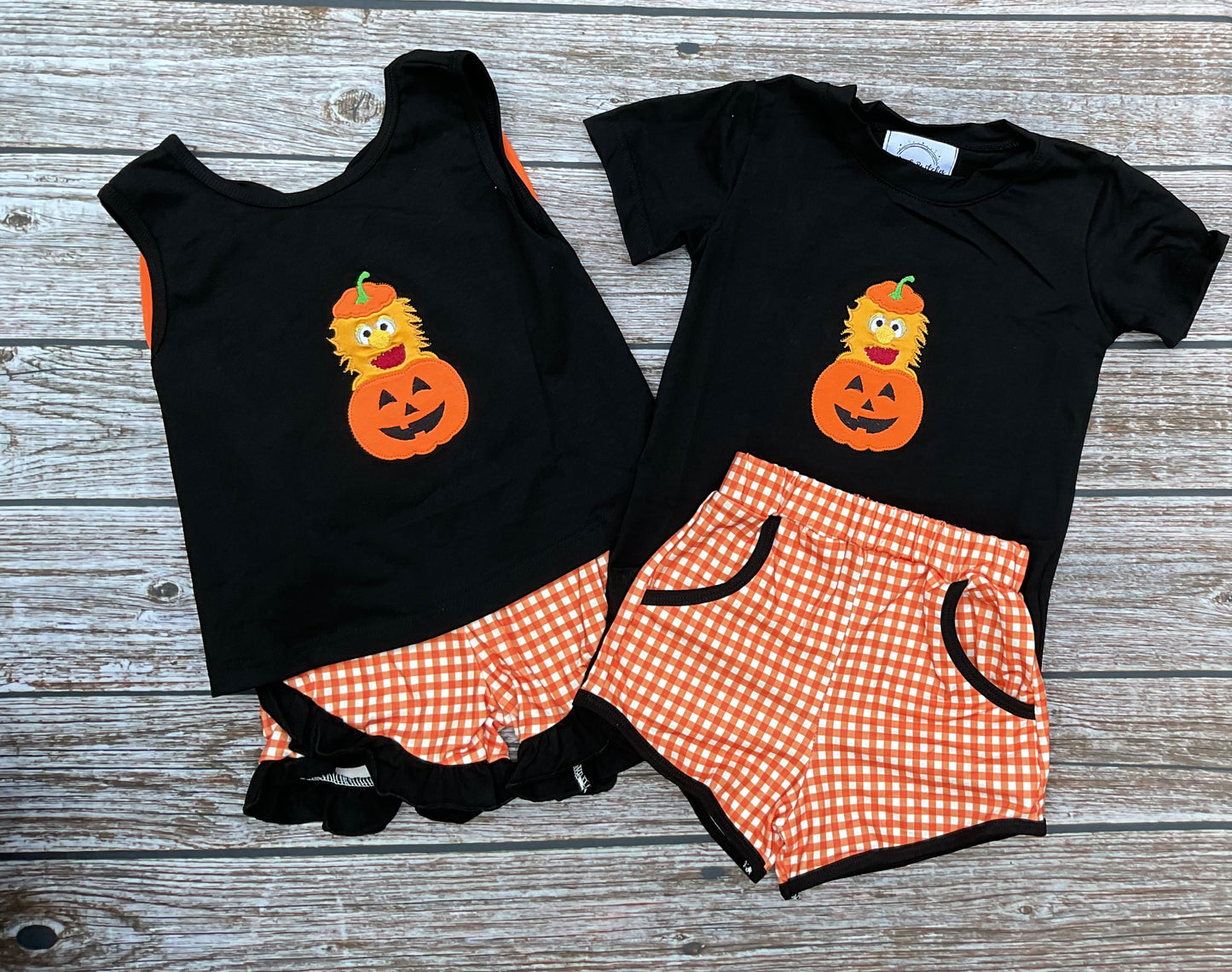 Halloween Herbie sibling matching outfits with boys and girls black pumpkin appliqué tops and orange gingham shorts.