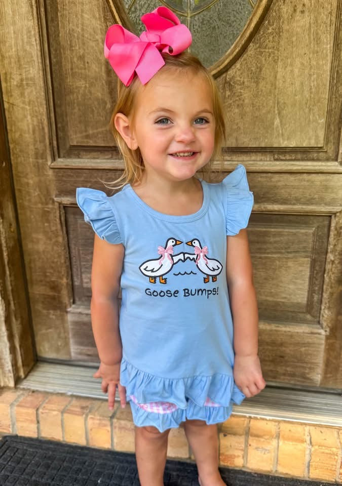 Girl wearing Oh My Goose Bumps blue embroidered goose short set with pink bow details