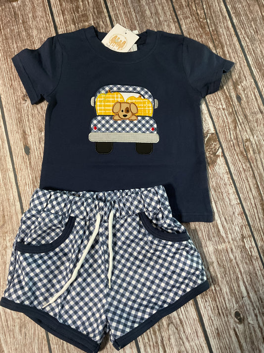 Pup in the Pumpkin Patch boys fall short set with navy puppy and pumpkin truck appliqué shirt and navy gingham drawstring shorts.