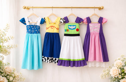 Storybook Adventure girls dress collection featuring four colorful character-inspired dresses in blue, yellow, green, purple and pink.